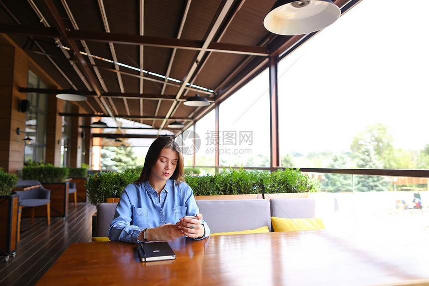 坐在街头咖啡馆的女学生图片