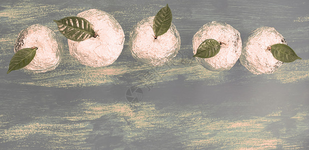 夹着天然绿色叶子的贝壳五金苹果Wooden糖果蓝背景图片