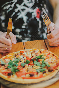 男人吃比萨饼用叉子和刀图片