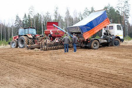 播种单元联合收割机播种机拖拉机和卡车自卸卡车和田间工人播种粮食从图片