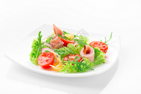 新鲜沙拉加西红柿黄瓜奶酪和火腿在白色盘子图片