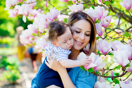 年轻红发母亲和孩子在阳光明媚的白天在春图片