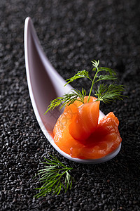 黑芝麻背景下的咸鲑鱼片配莳萝图片