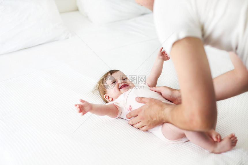 六个月的婴儿和父亲在床上玩耍幸图片