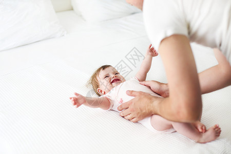 六个月的婴儿和父亲在床上玩耍幸图片