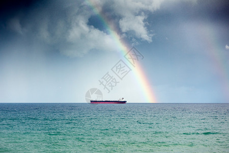 希腊天空中的船和彩虹的远景图片