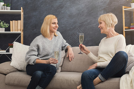 快乐的成年母亲和女儿一起共度时光聊天分享新闻周末在家喝香槟图片
