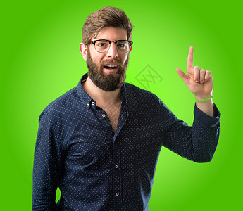 长胡子大胡子的年轻时装男用手指对着绿色背图片