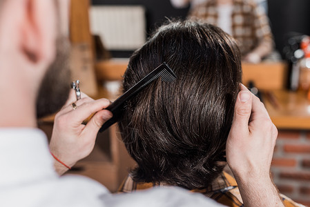 理发师在理发店梳理顾客头发的短片图片