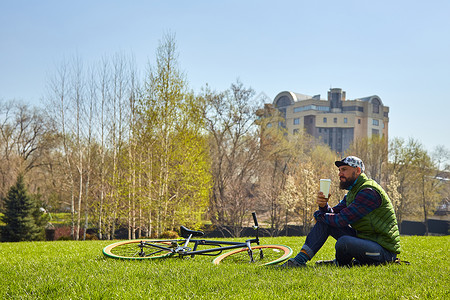 年轻人骑自行车坐在草坪上图片