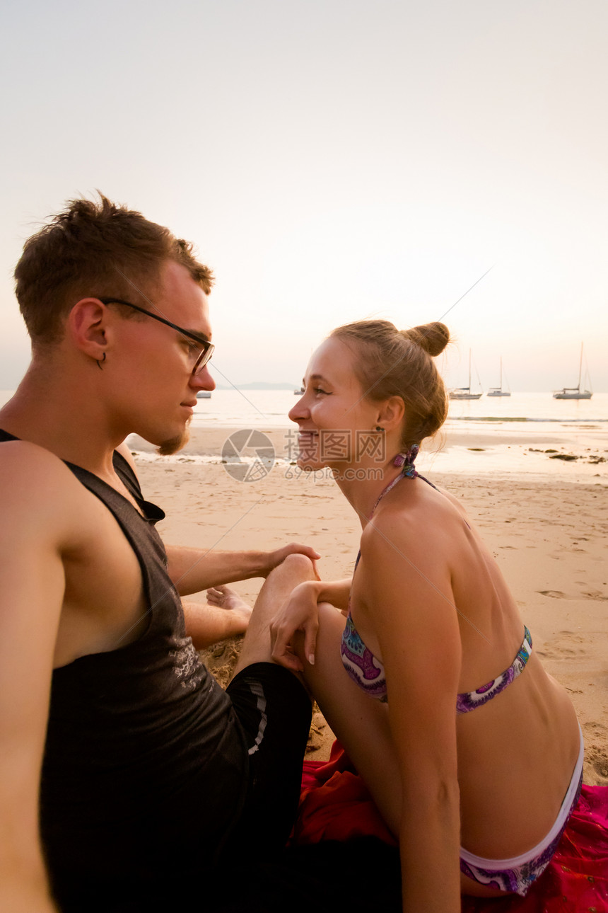 在泰国的KohMook岛上的热带金色日落美丽的年轻夫妇在蜜月期间在查理海滩上拍摄图片