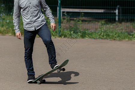 不知名型的年轻滑板运动员准备乘草签机在温暖的夏日图片