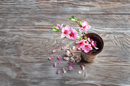 木桌上花瓶里开着美丽花朵的树枝图片