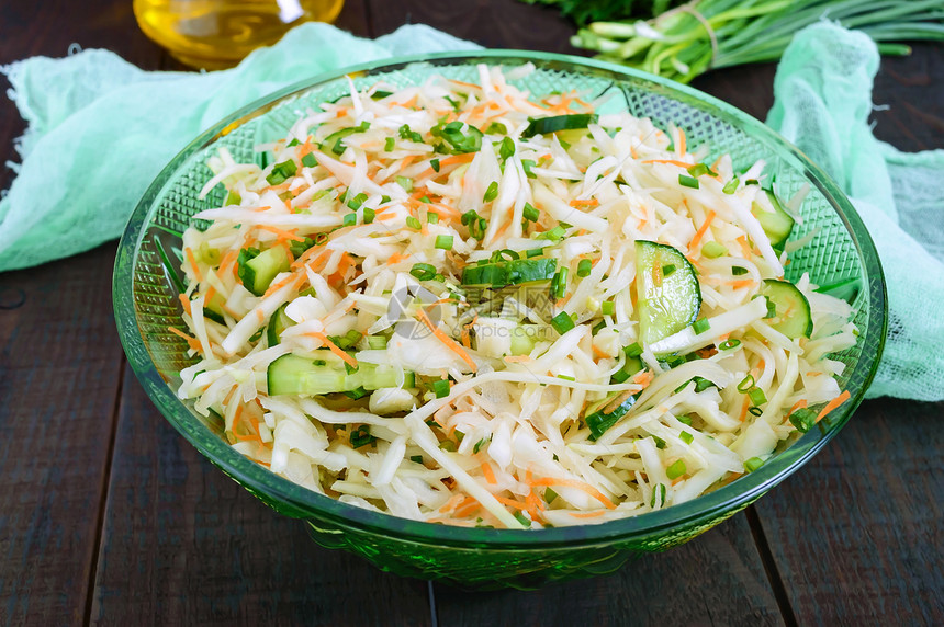 白菜黄瓜胡萝卜蔬菜的膳食沙拉多汁的春季沙拉配新鲜蔬菜在木桌上图片