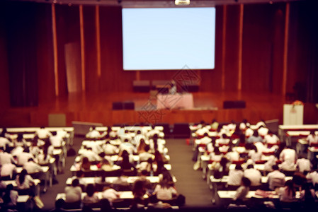 毕业典礼上新生迎新日或国际会议厅演讲的学生观众和主题演讲者形象模糊图片