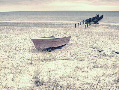 海湾沙滩上弃置的渔船桨清晨无风时图片