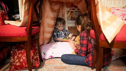 1岁幼儿男孩在卧室的帐篷里与大姐图片