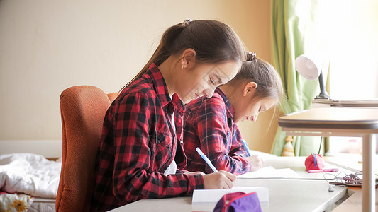 2名少女在学校课本中写图片