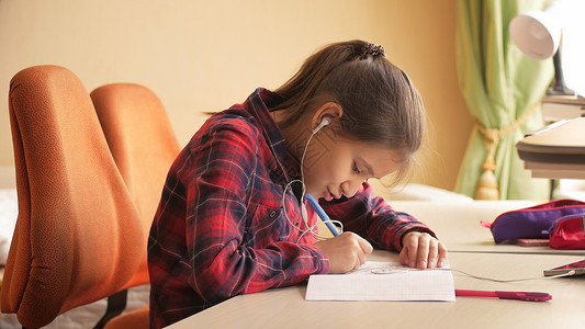 少女在做功课时听音乐和的触图片