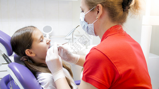女牙医在诊所检查女孩牙齿图片