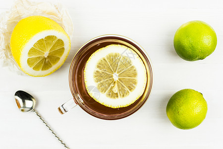 一杯热茶白桌上的圆形新鲜柠檬片图片
