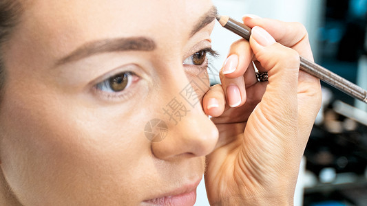 化妆师用铅笔绘画模特眼图片