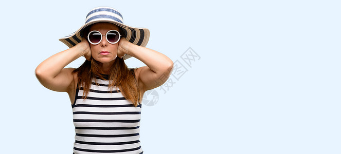 中年酷女人戴着夏天的帽子和太阳镜遮住耳朵图片