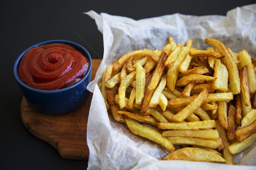 薯条和番茄酱加木板的薯条深底图片