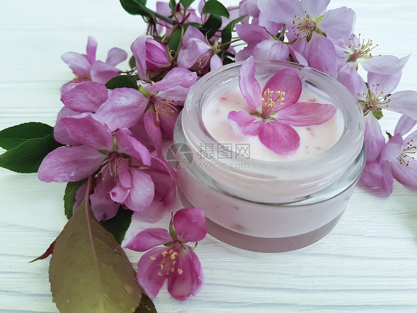 白色木头上的奶油化妆品粉红色花朵图片