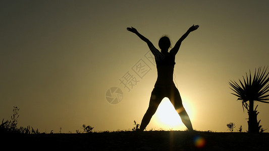 做瑜伽姿势的运动妇女站着高举双手反对日图片