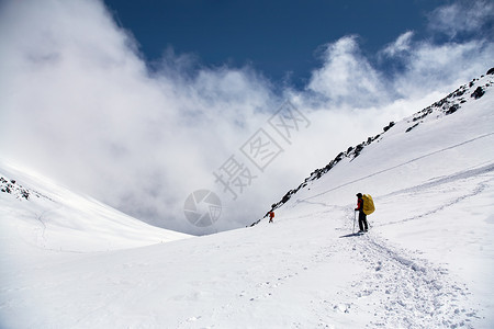 一群登山者在山上爬到顶部图片