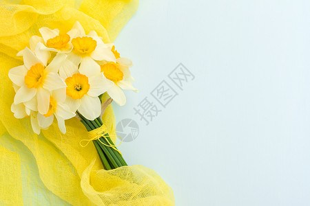 蓝色柔和背景上带有黄色纺织装饰的水仙花束图片