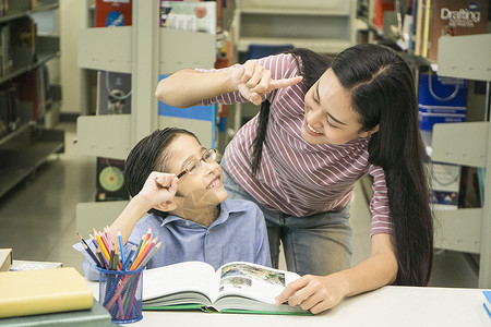 女教师和小学生在书架背图片