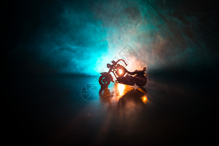 大功率摩托车斩波器夜间与男子骑手背景光的雾空的间图片
