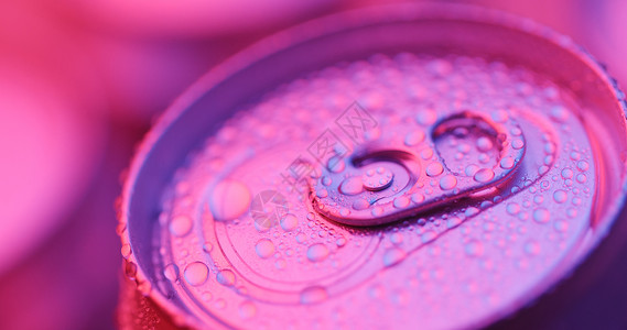 紫色灯光下的铝制饮料罐图片