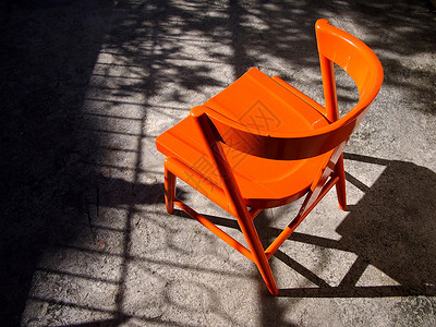 户外车库里一张新涂的亮橙色木椅的照片图片