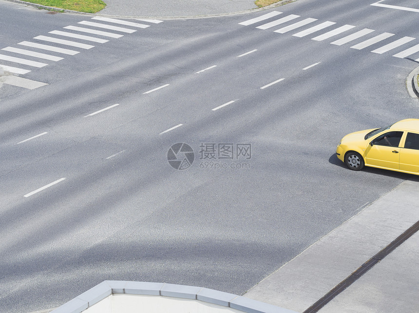 白天有黄色汽车的城市道路交叉口图片