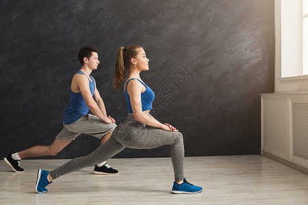 室内灰色背景的男女青年在健身房复制空间进行有氧锻炼活动时图片