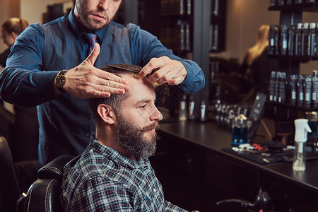 一位时尚的理发师为客户理发理发店的男士理发用图片