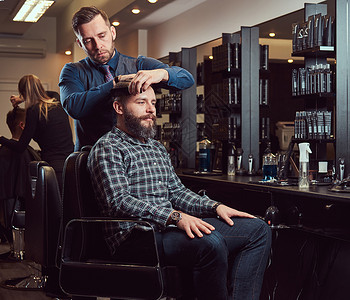 一位时尚的理发师为客户理发男士在理发店理发用图片