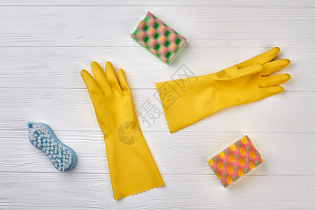 厨房海绵和橡胶手套黄色乳胶手套和厨房海绵白色木制图片