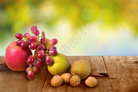 秋天在木桌背景上收获的果实苹果梨椰子图片