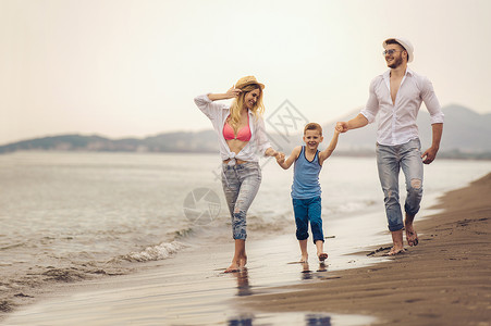 快乐的年轻家庭在沙滩上玩得开图片