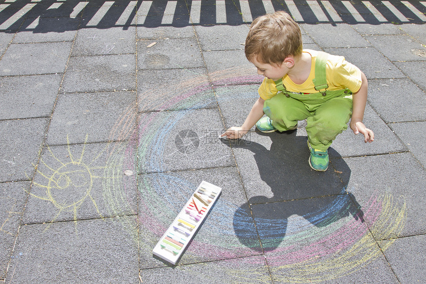 可爱的男孩用彩色粉笔在沥青上画适合小孩子的夏季活动和创意游戏孩子一起玩得开心学校和假期的概图片