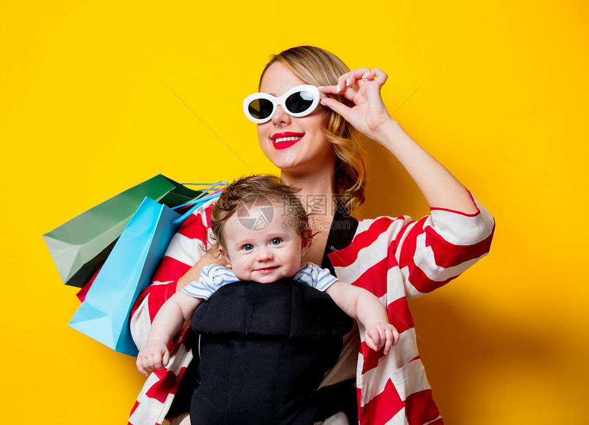母体和小婴儿在载体中有一个带有包袋的购物店图片