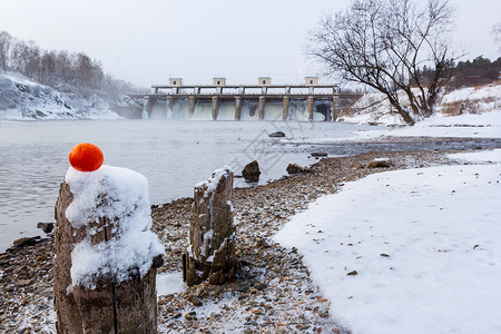 冬天在河边的旧沙堆上用橙色在大坝背景之下不图片