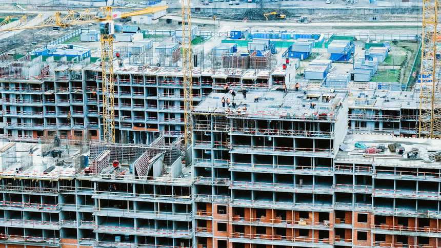 在建筑工地特写工作的延时建造者和起重机图片