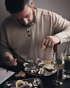 吃新鲜牡蛎的有胡子的人图片