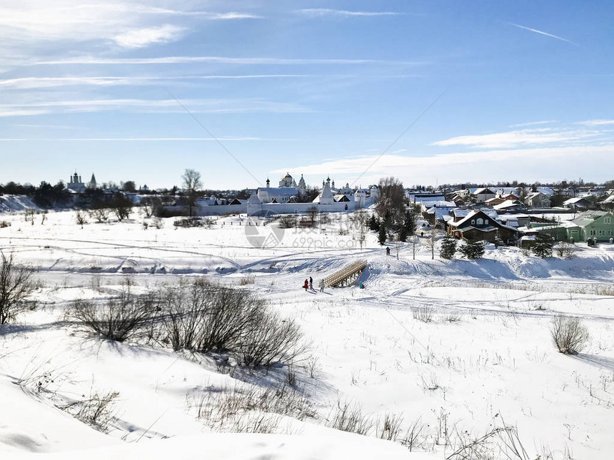 俄罗斯弗拉基米尔州苏兹达尔镇冬季冻结的河流岸上的波克罗夫斯基修道院中间十图片