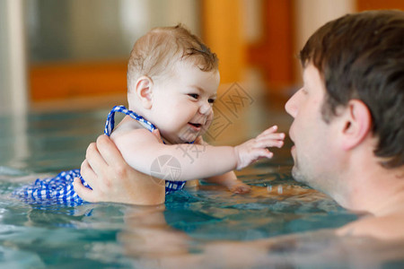 快乐的中年父亲和可爱的小女儿在漩涡池里游泳图片